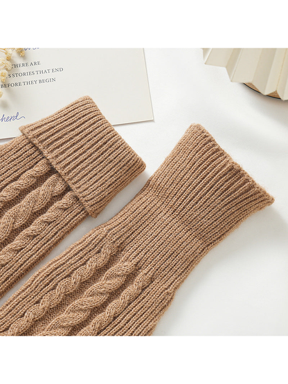 Close-up of brown cable-knit gloves with folded and extended ribbed cuffs