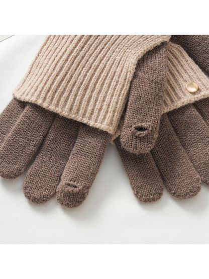 Close-up of fingertip openings and gold-tone button on two-tone knit gloves