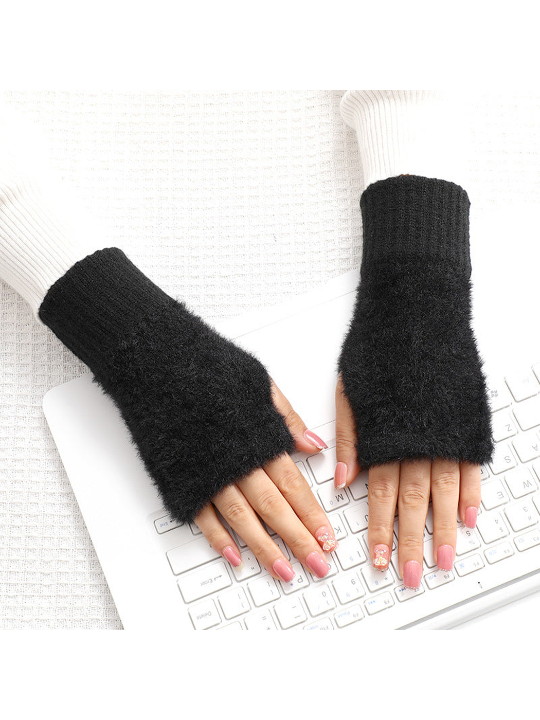 Black fuzzy fingerless gloves worn over the hands