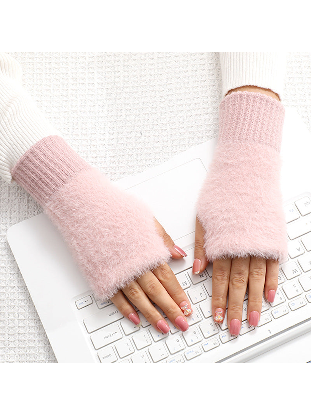 Light pink fuzzy fingerless gloves worn over the hands