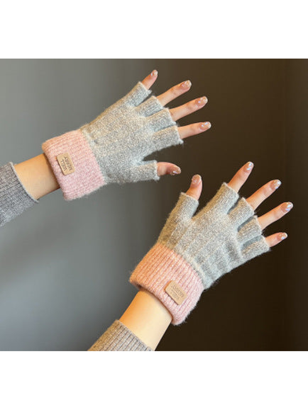 Gray and pink colorblock fingerless gloves worn on hands