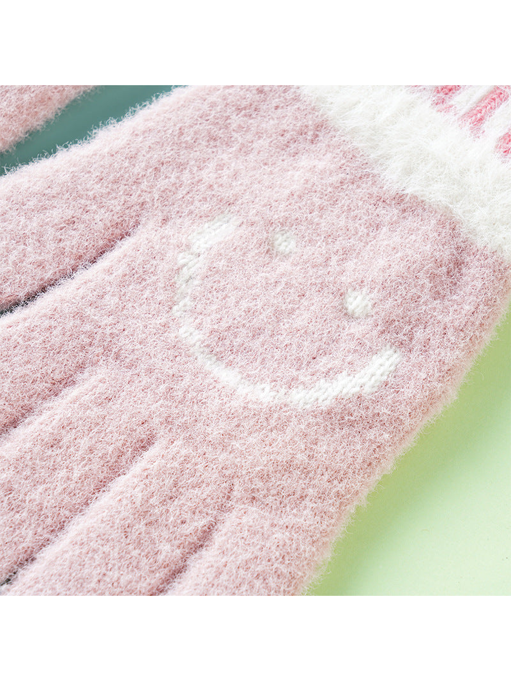Close-up of the fuzzy pink glove and white smiley motif