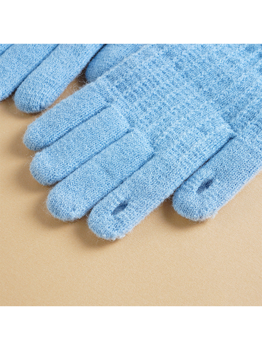 Close-up of the knit texture and dark fingertip inserts on light blue gloves