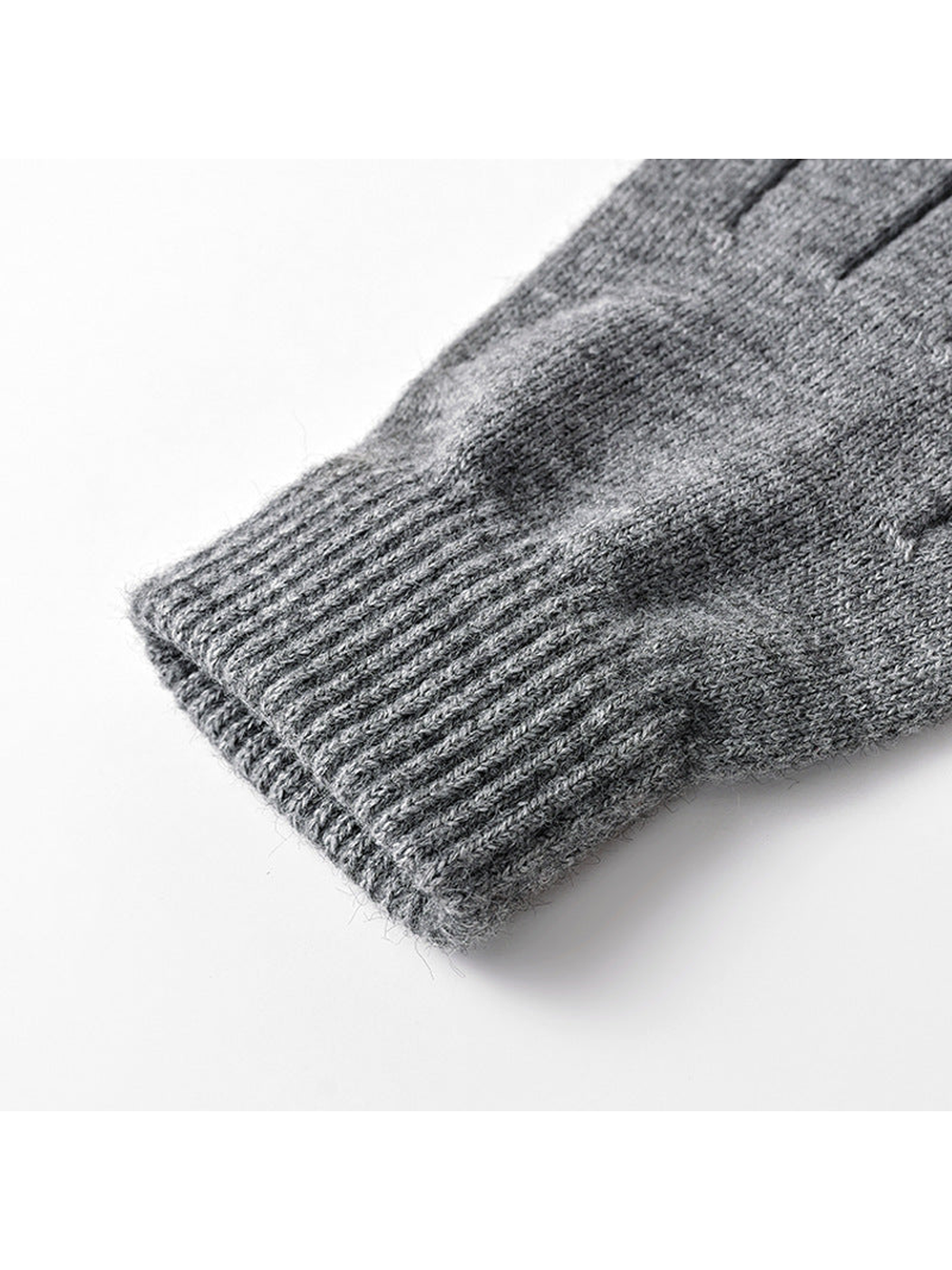 Close-up of the ribbed cuff on deep gray knit gloves