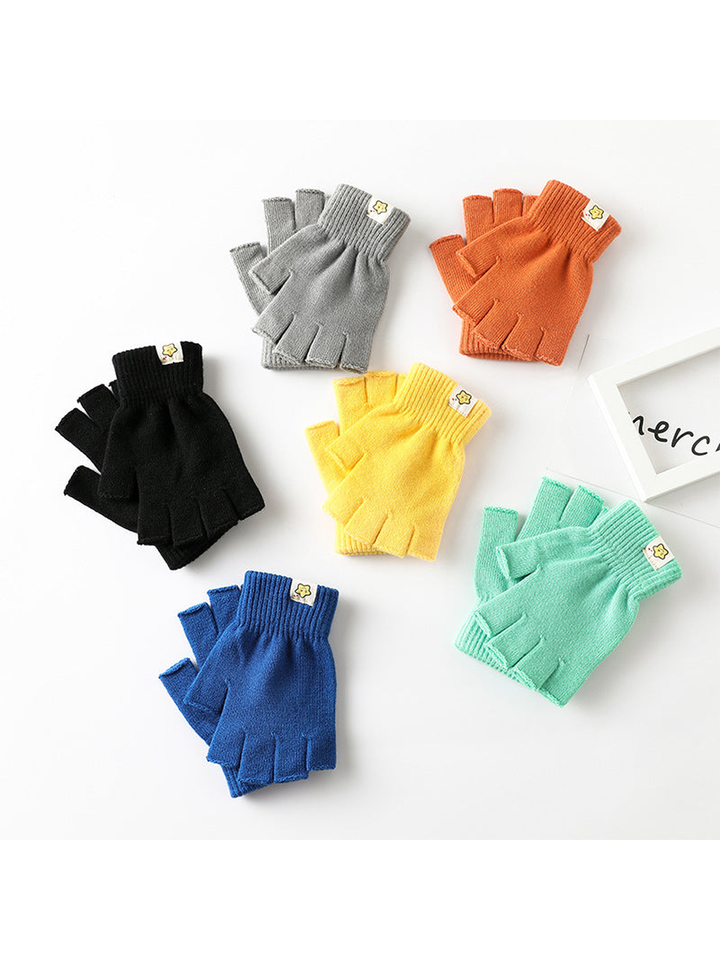 Six pairs of colorful fingerless gloves arranged on a white surface