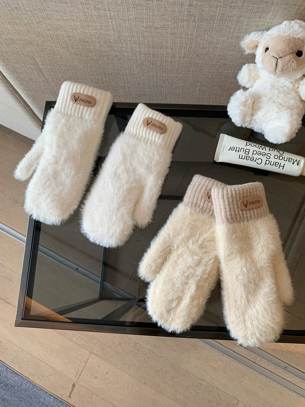 Ivory and cream fuzzy mittens displayed together