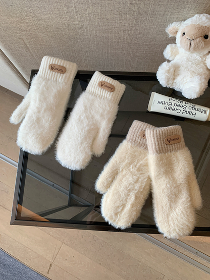 Ivory and cream fuzzy mittens displayed together