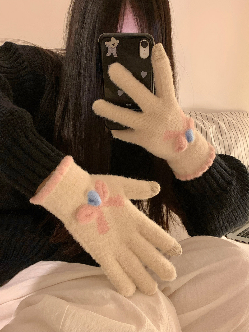 Ivory flower-motif gloves worn with a black sweater
