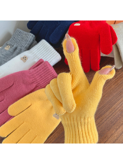 Yellow knit glove worn to show the open thumb and index fingertips