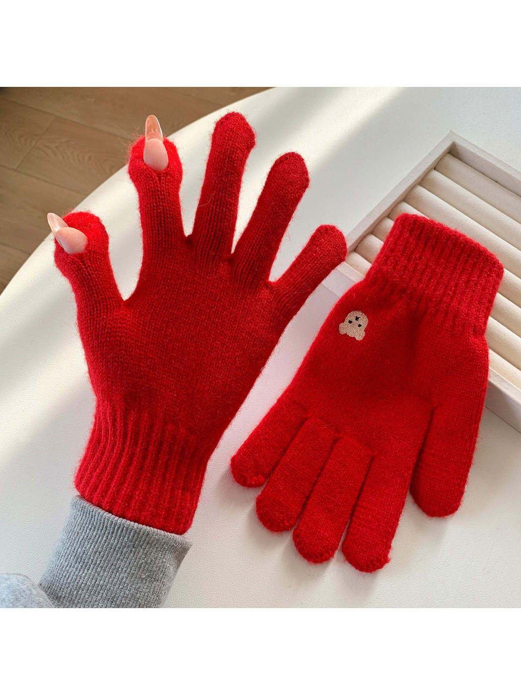 Red knit gloves with open thumb and index fingertips