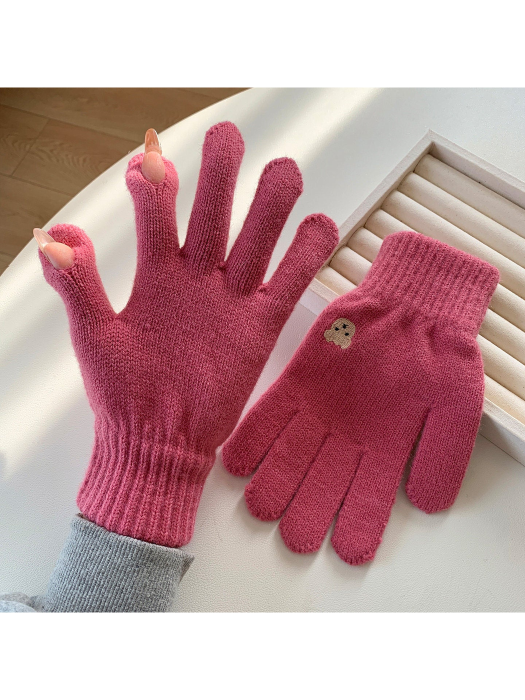 Dusty pink knit gloves with open thumb and index fingertips