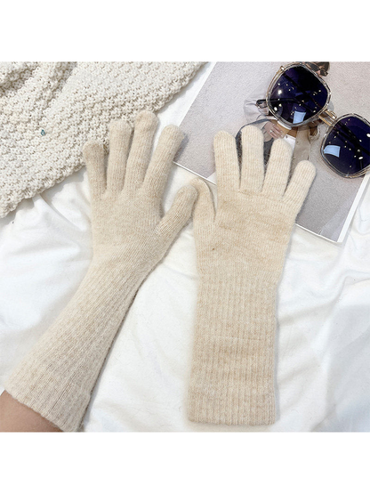 Beige extended-cuff gloves worn on both hands