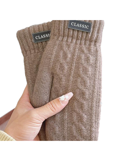 Close-up of brown knit-look mittens with ribbed cuffs and label patches