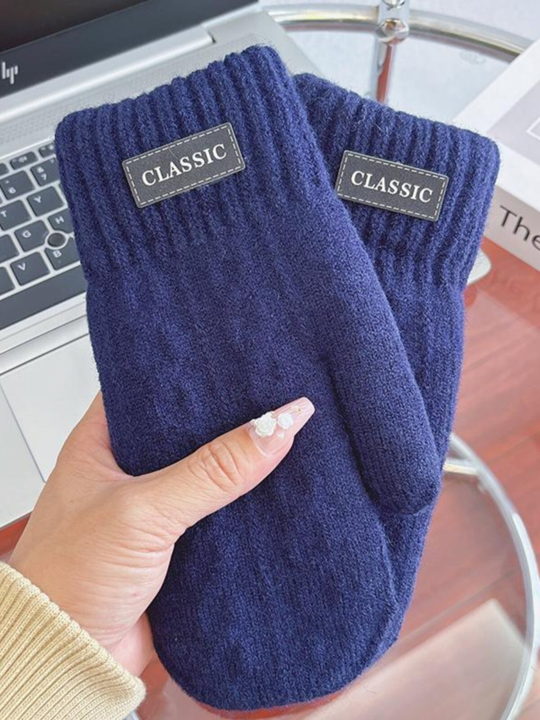 Navy knit-look mittens with ribbed cuffs and label patches, handheld view
