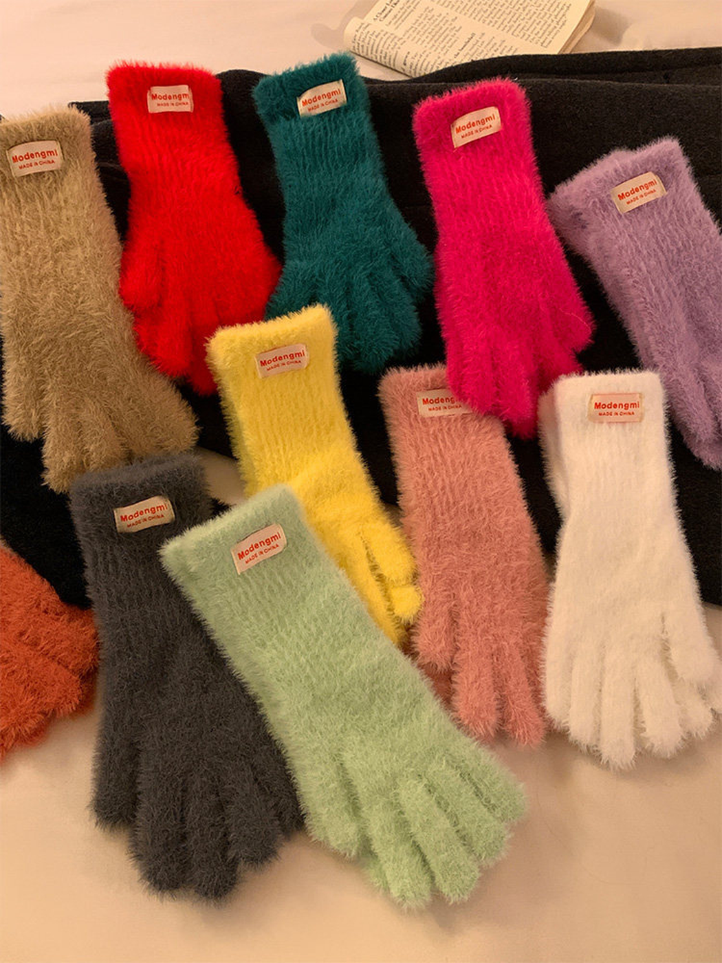 Multiple colors of fuzzy gloves displayed in a layered arrangement