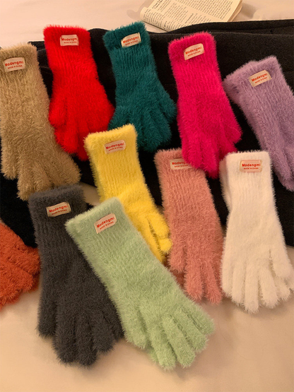 Multiple colors of fuzzy gloves displayed in a layered arrangement