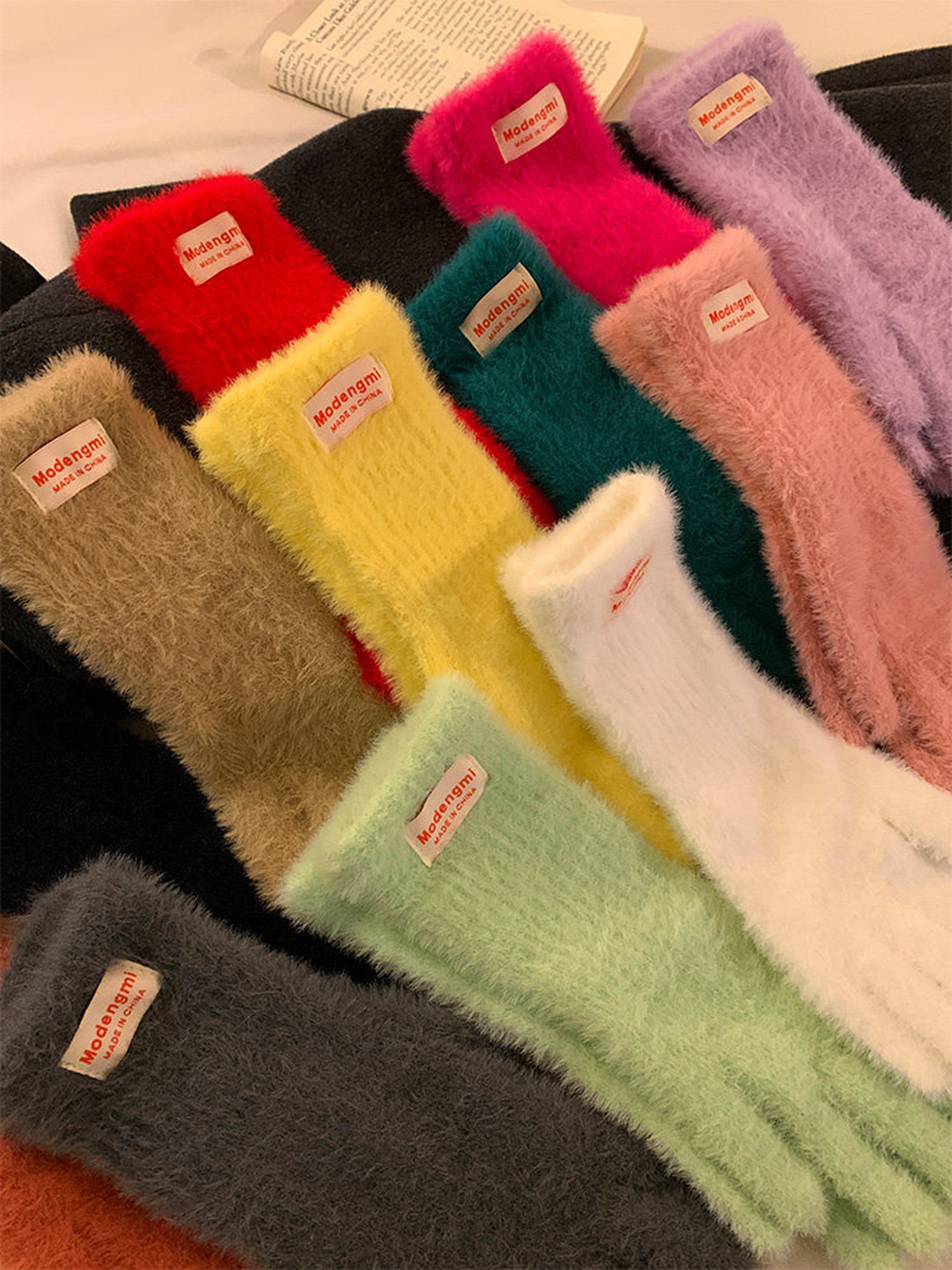 Assorted fuzzy gloves in overlapping rows showing extended cuffs