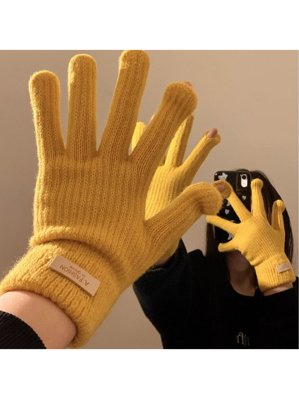 Mustard yellow knit gloves worn with open thumb and index fingertips visible