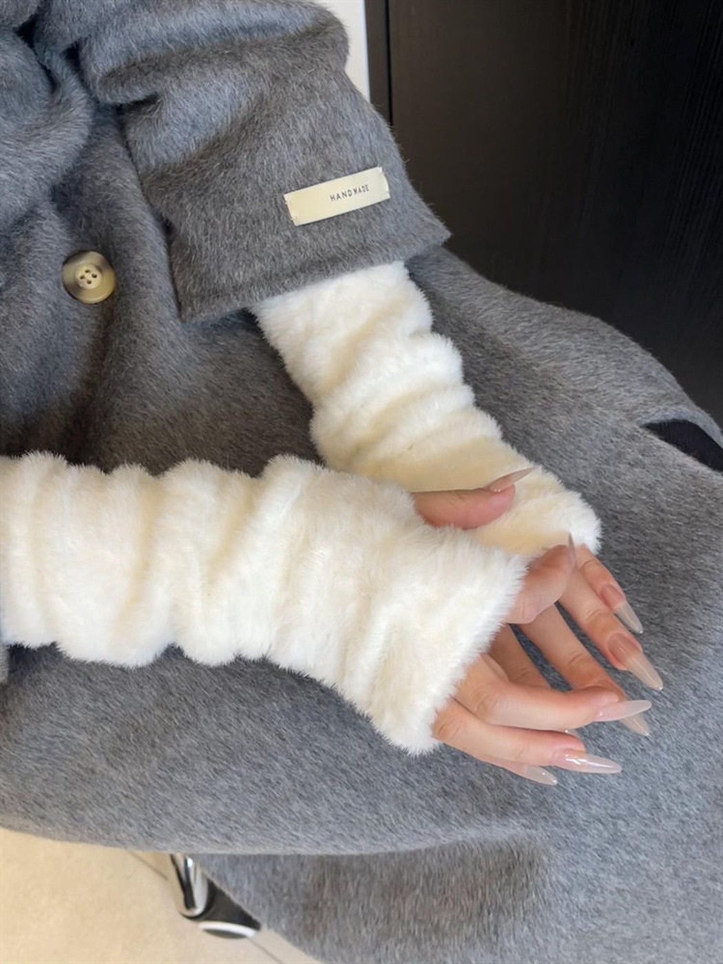 Ivory fuzzy fingerless gloves styled with a gray coat