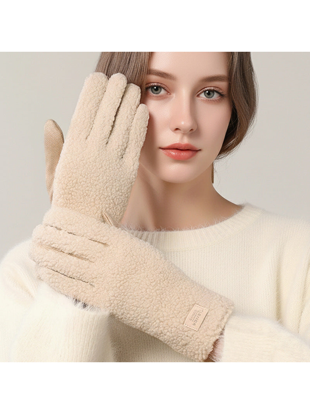Beige textured gloves worn with an ivory sweater
