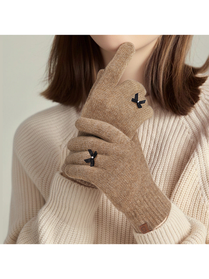 Camel bow-accent knit gloves worn with a cream sweater