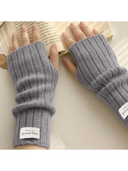 Gray ribbed fingerless gloves worn while reading a book