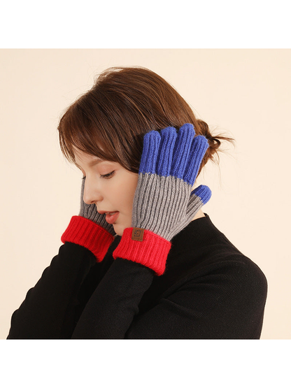 Blue, gray and red colorblock gloves worn with folded cuffs