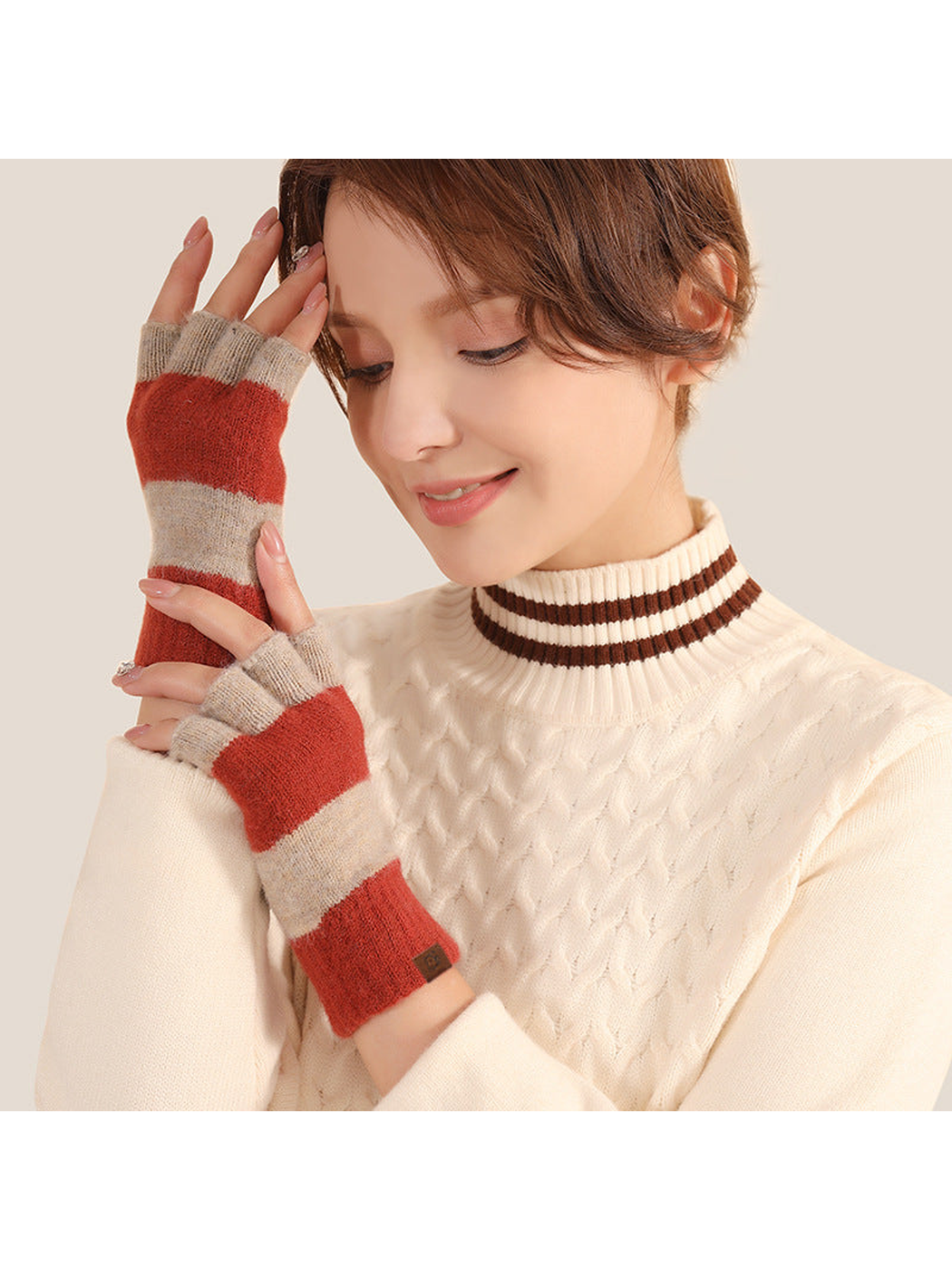 Red and gray striped fingerless gloves worn with a cream sweater