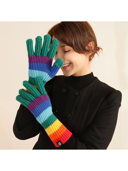 Green fingertip rainbow striped gloves worn with extended cuffs