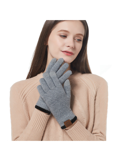 Gray knit gloves worn with a beige sweater