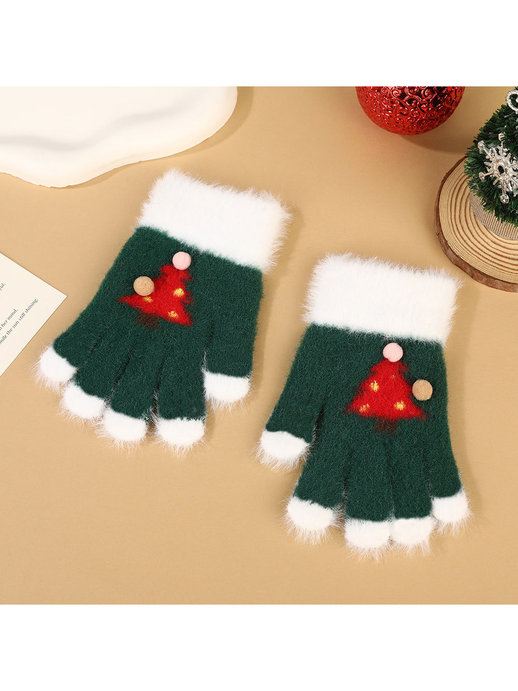 Green fuzzy fingerless gloves with white trim and red Christmas tree motifs