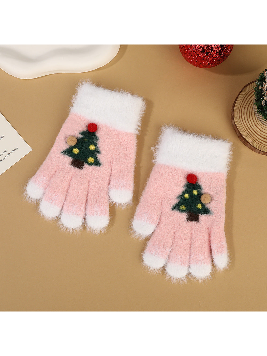 Light pink fuzzy fingerless gloves with white trim and Christmas tree motifs
