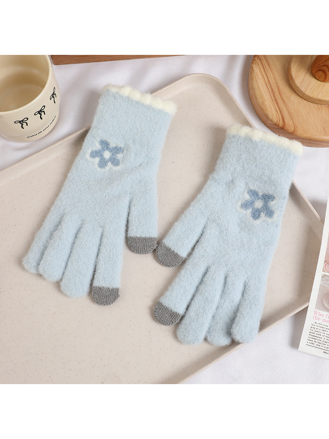 Light blue fuzzy gloves with blue flower motifs and gray fingertips