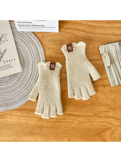 Pair of ivory ribbed fingerless gloves laid flat