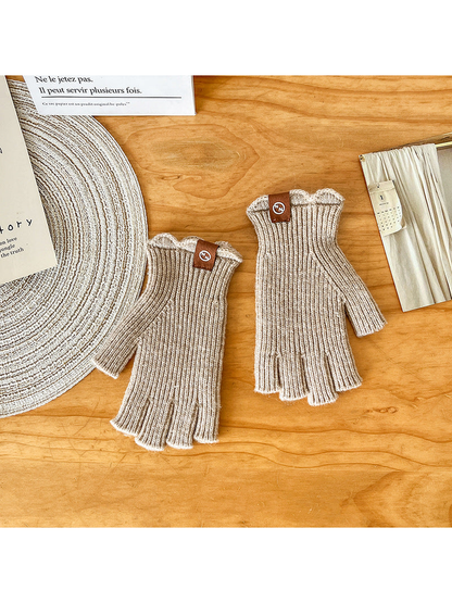 Pair of greige ribbed fingerless gloves laid flat