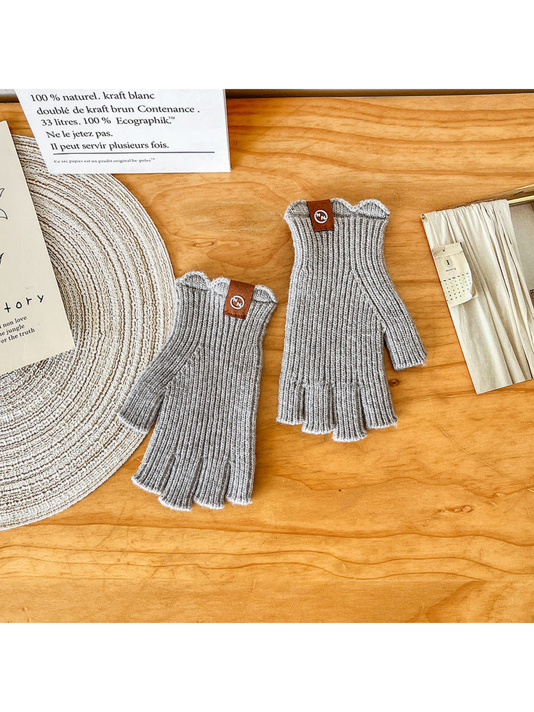 Pair of light gray ribbed fingerless gloves laid flat