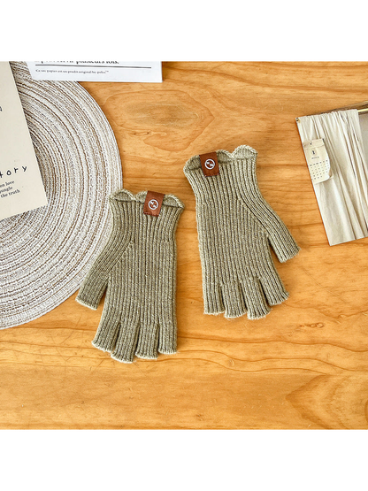 Pair of light green ribbed fingerless gloves laid flat
