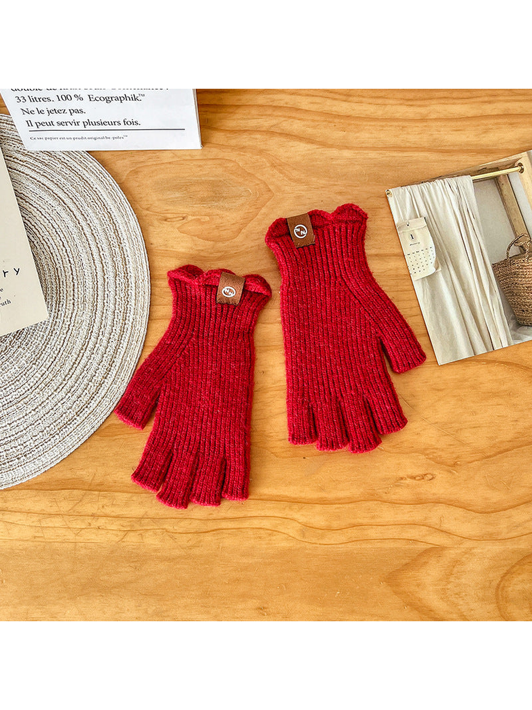 Pair of red ribbed fingerless gloves laid flat