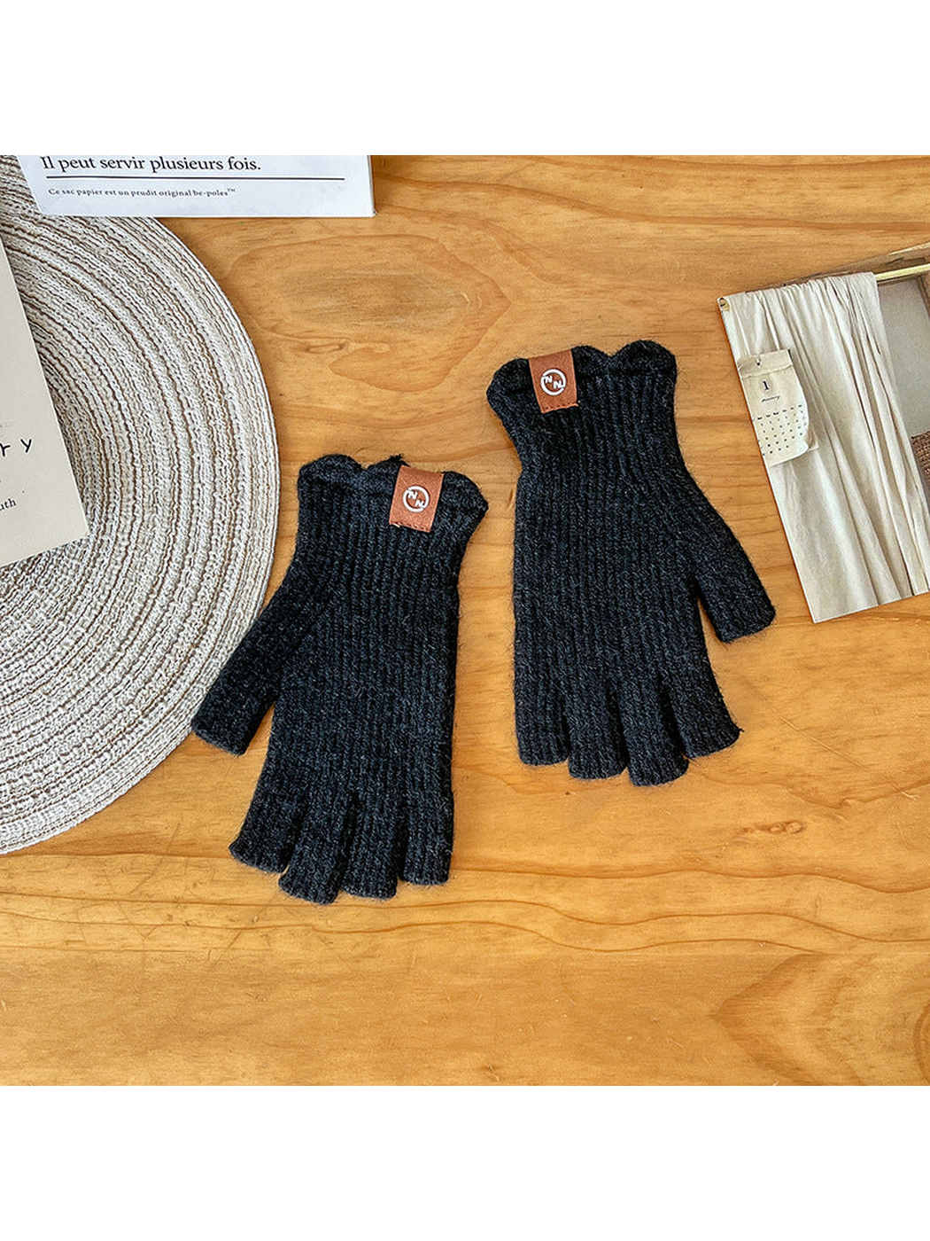 Pair of black ribbed fingerless gloves laid flat