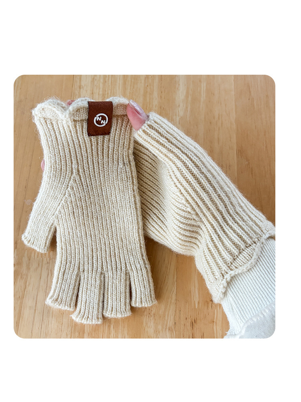 Ivory ribbed fingerless gloves shown worn and held against a wood surface