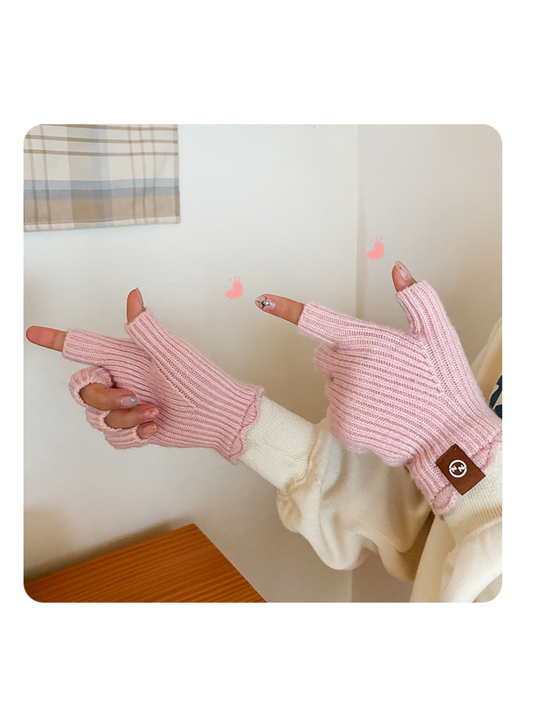 Light pink ribbed fingerless gloves worn in a pointing pose