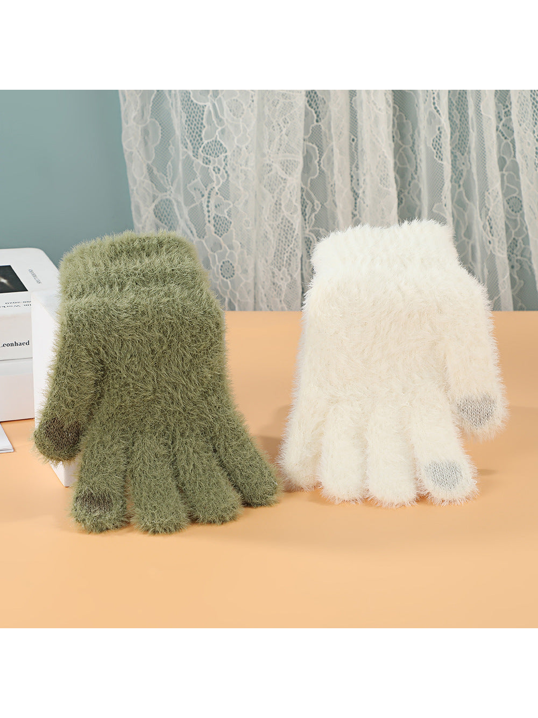 Sage green and ivory fuzzy gloves standing side by side