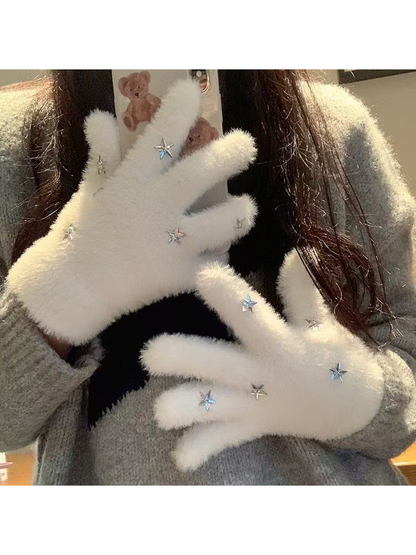 White fuzzy star gloves worn while holding a phone