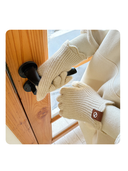 Ivory ribbed gloves worn while opening a wooden door