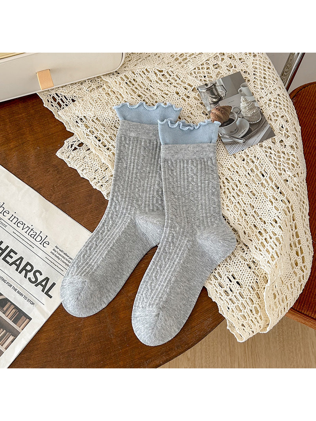 Light gray crew socks with blue ruffled cuffs and ribbed geometric texture