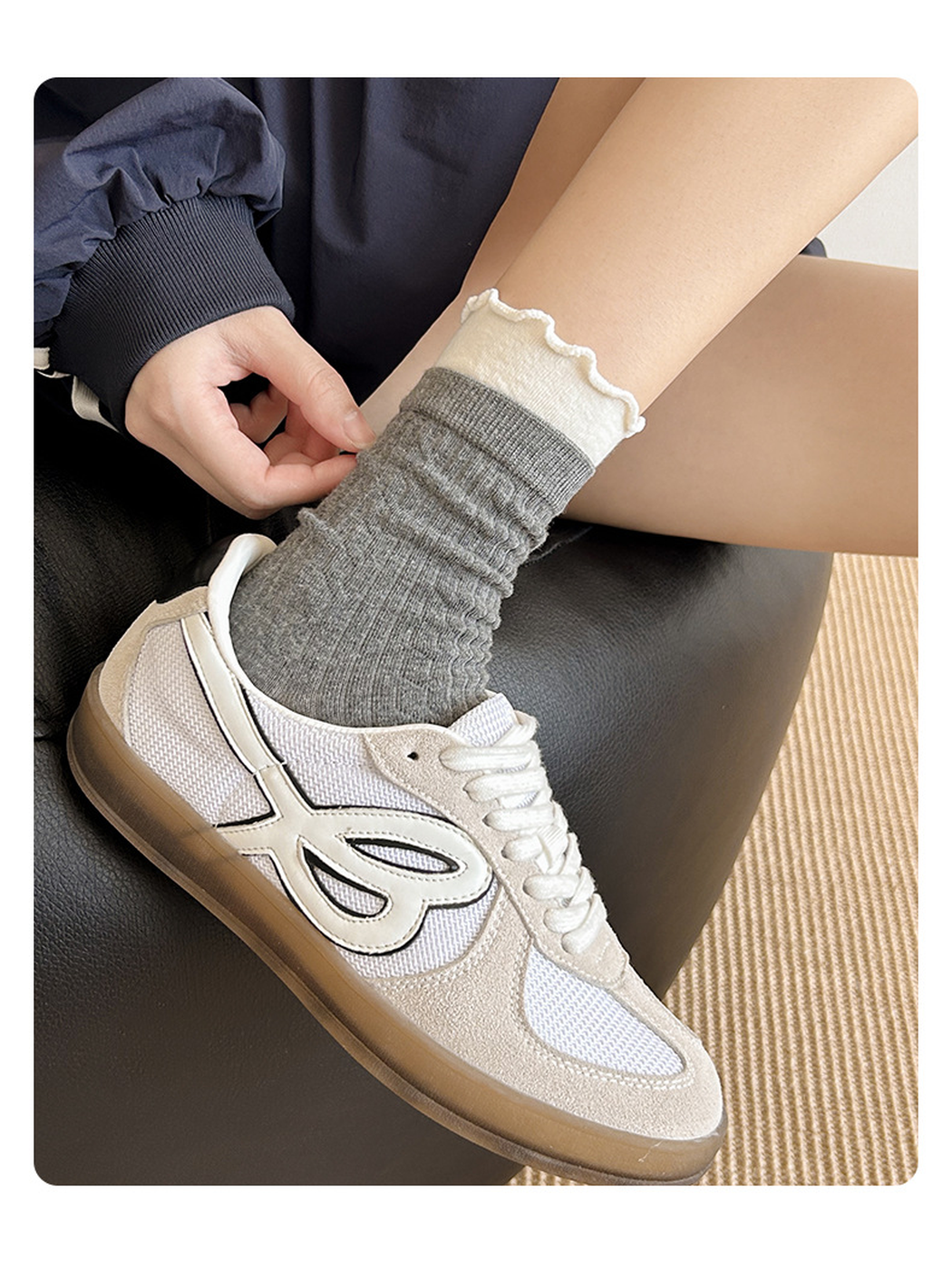 Dark gray crew sock with a white ruffled cuff styled with a neutral sneaker
