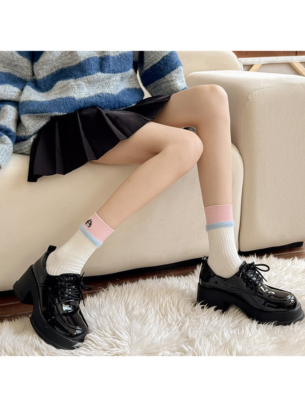 Ivory crew socks with pink embroidered cuffs styled with black shoes