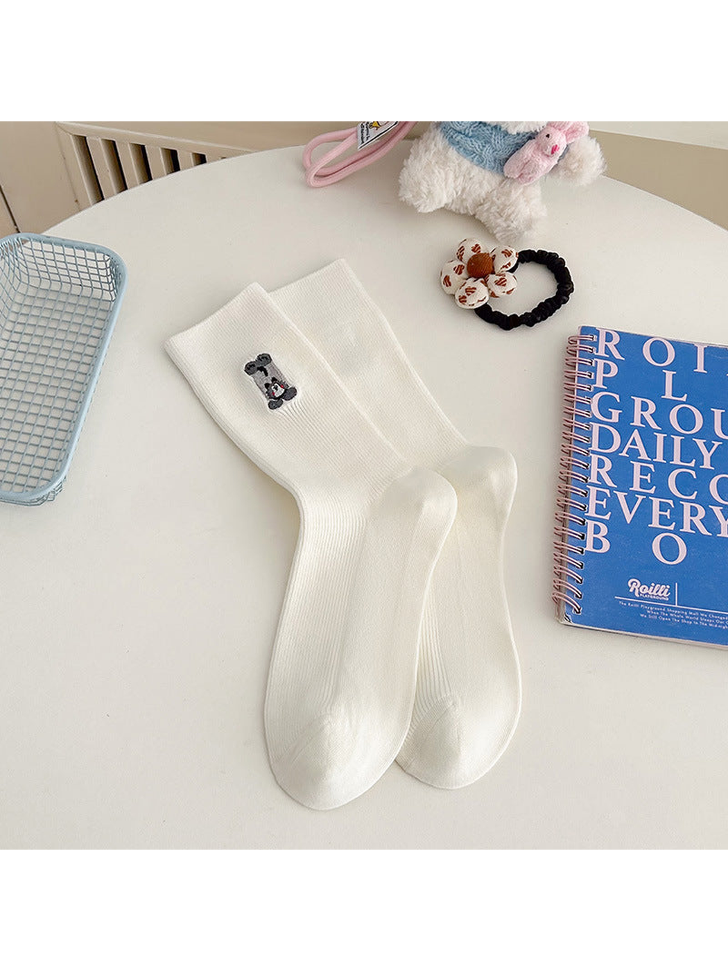 White ribbed crew socks with an embroidered gray animal motif