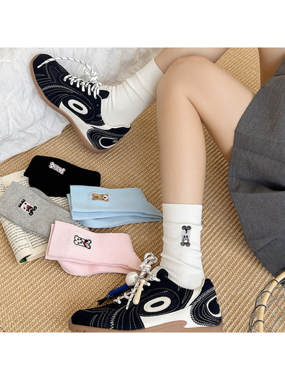 White embroidered crew socks worn with sneakers beside assorted color options