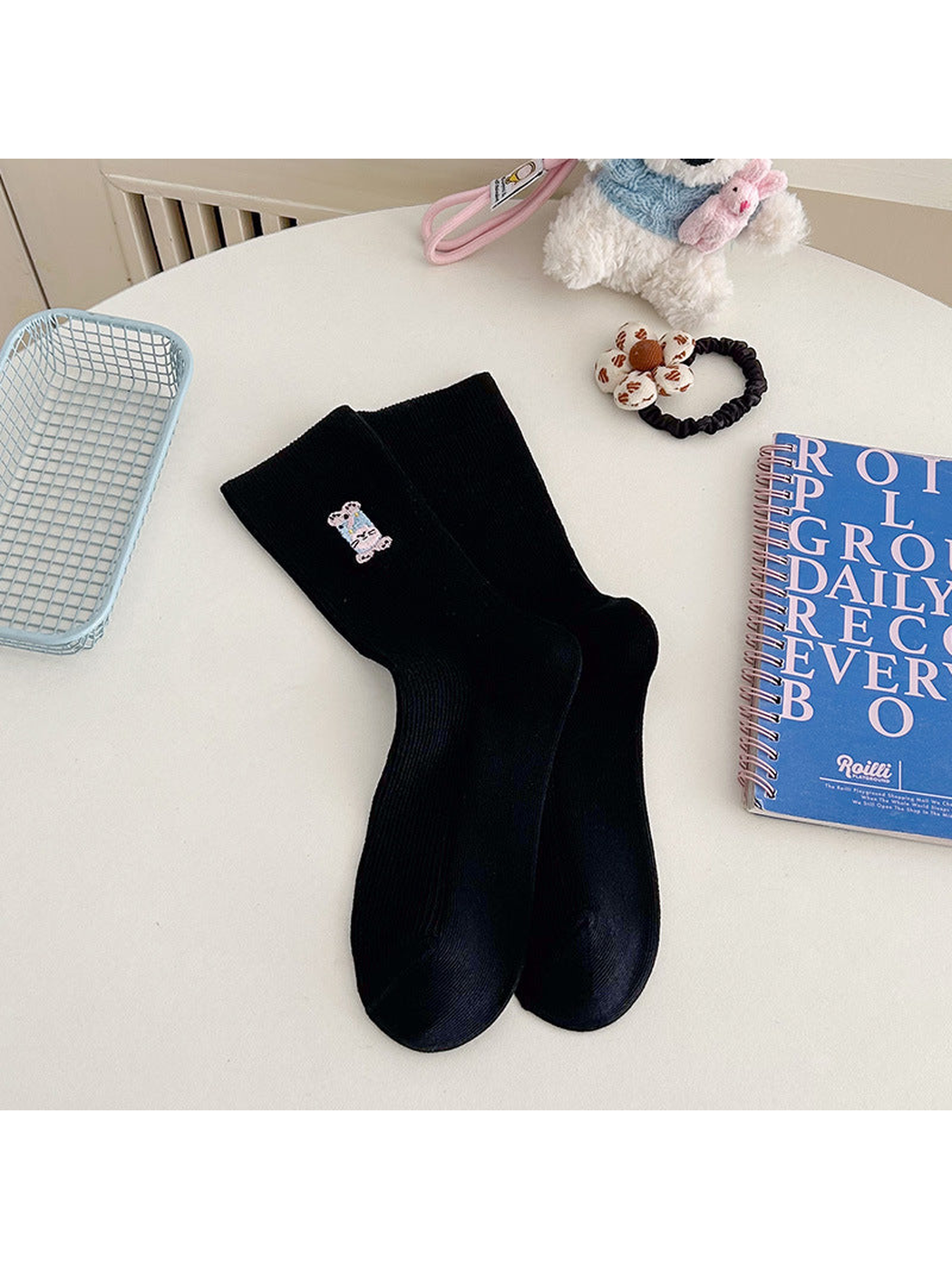 Black ribbed crew socks with a small embroidered animal motif